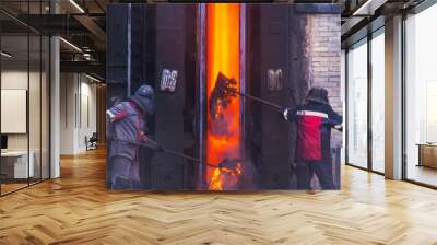 Workers of the coke oven throw the remnants of hot coke into the coke battery oven Wall mural