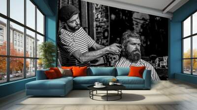 Working hair scissors. Bearded man in barbershop. Hairdresser cutting hair of male client. Hairstylist serving client at barber shop. Black and white Wall mural