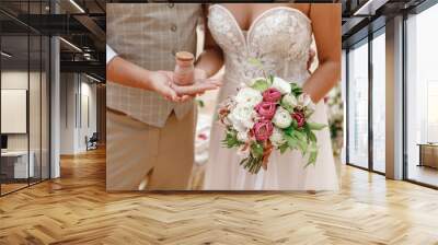 Bride and groom holding bottle with sand after tropical wedding ceremony on the beach Wall mural