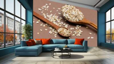 oat flakes in a two wooden spoon on a brown background Wall mural