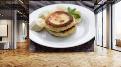 two curd fritters with sliced banana in a white plate Wall mural