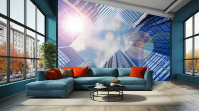 business and financial skyscraper buildings concept.Low angle view and lens flare of skyscrapers modern office building city in business center with blue sky. Wall mural