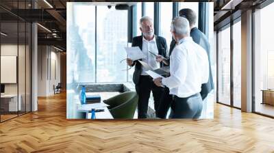 Meeting and discussion concept.business people communicating in office.Mature businessman discuss information with a colleague in a modern business lounge high up in an office tower. Wall mural