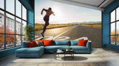 New year 2024 or start straight concept.word 2024 written on the asphalt road and athlete woman runner stretching leg preparing for new year at sunset.Concept of challenge or career path and change. Wall mural