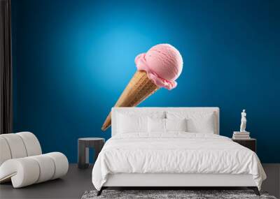 Pink ice cream scoop in a waffle cone against a bright blue background. Wall mural