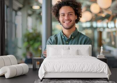 A smiling confident young business man standing with arms crossed in a modern office. a happy handsome curly haired male entrepreneur with his hands folded across his chest. generative AI Wall mural