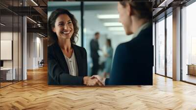 Happy mid aged business woman manager handshaking greeting client in office. generative AI Wall mural