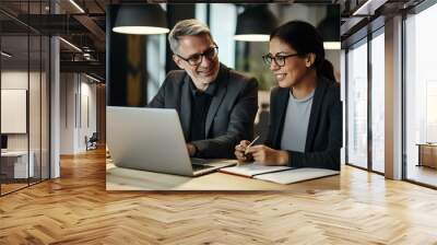 Happy professional mid aged mature executive manager working in office with female colleague, talking and looking at laptop computer sitting at table workplace. generative AI Wall mural