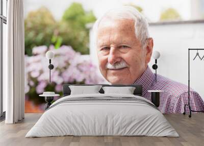 portrait of senior, old men smile and is relaxed in his garden with a white wand Wall mural