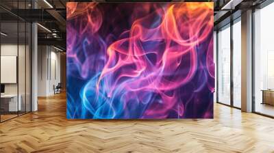 Colorful smoke is swirling and mixing, creating abstract shapes on a black background Wall mural