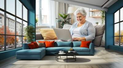 A plus size woman is sitting in a bright room and working on a laptop Wall mural