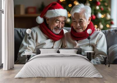 happy retired men and women in a Santa Claus hat are smiling and making a video call.  The concept of an active lifestyle and leisure for pensioners on Christmas Eve Wall mural