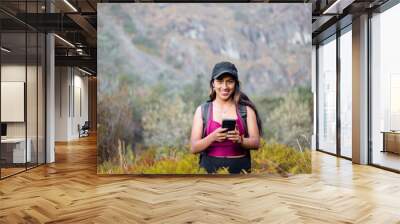 Atractiva joven turista con short  responde a videollamadas al aire libre, chica inteligente se comunica con entusiasmo en conferencia en línea al aire libre,  turista hablando de grabar contenido Wall mural