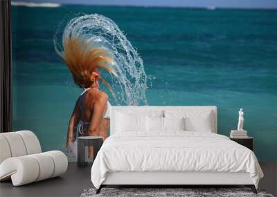 woman flips hair in turquoise waters Wall mural