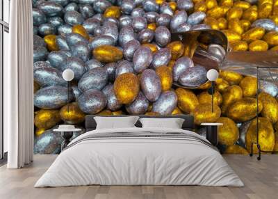 Metal scoop with colorful glazed in gold and silver chocolate candies, candy shop Wall mural