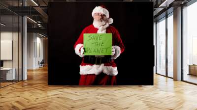 Santa Claus with a Save the Planet sign on black background Wall mural