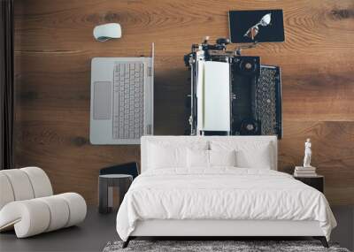 Office through the time. Wooden desk with old fashioned typewriter back-to-back with a modern laptop computer Wall mural