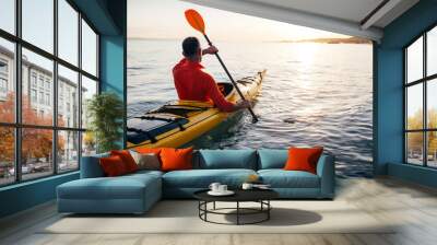 Senior man paddling kayak on the sunset sea Wall mural