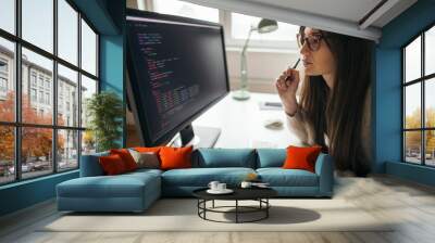 Young woman programming at her home office Wall mural