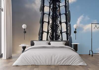 Telecommunication tower cellular. Macro Base Station. 5G radio network telecommunication equipment with radio modules and smart antennas mounted on metal against a clouds sky background (20) Wall mural