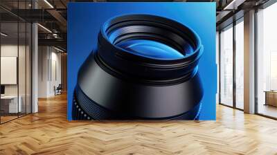 Close-up of a camera lens against a blue background highlighting photography equipment and detail Wall mural