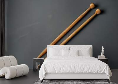 Two wooden drumsticks lying on a dark surface with a soft shadow Wall mural