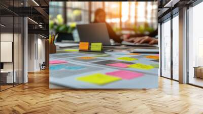 collaborative team working together around a table, hands visible, using sticky notes to brainstorm ideas. The scene emphasizes teamwork, creativity, and problem-solving Wall mural