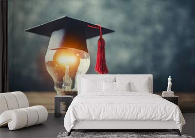 glowing light bulb adorned with a graduation cap, representing innovation and academic achievement Wall mural