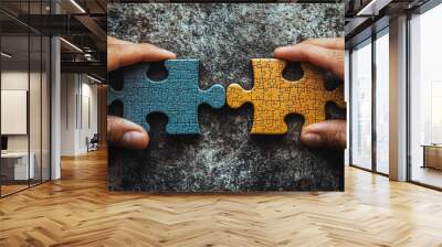 Two hands hold individual jigsaw puzzle pieces, symbolizing teamwork and collaboration in solving complex problems and finding solutions. Wall mural