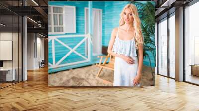 Woman posing with near beach house Wall mural