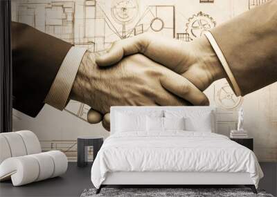 Close-up of two hands shaking over a technical blueprint emphasizing partnership collaboration and trust in a business project
 Wall mural