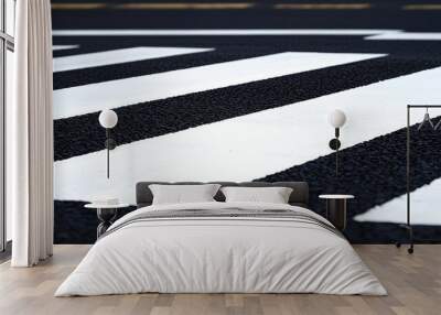 A close-up view of a black asphalt road featuring white pedestrian crosswalk stripes. Wall mural