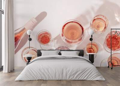 Many glasses of rose wine and bottle sparkling pink wine top view. Light alcohol drink for party. Wall mural