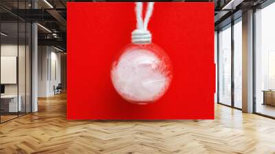 Transparent christmas glass ball hanging with red background. New Year eve decoration. Winter Holiday background with copy space. Wall mural