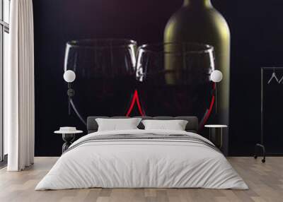 Two glasses of red wine, a bottle on a wooden table. Wall mural