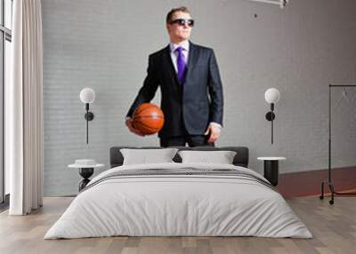 Angry business man with basketball. Wearing dark sunglasses. Wall mural