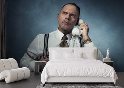 Angry retro 1940 man on the phone sitting on chair in room. Wall mural