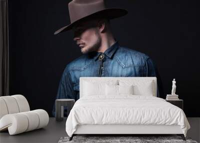 Modern fashion cowboy. Wearing brown hat and blue jeans shirt. B Wall mural