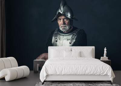 Senior knight in armor holding sword. Wall mural