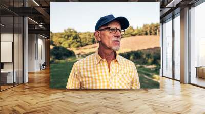 Senior man with beard and cap outdoors in park. Wall mural