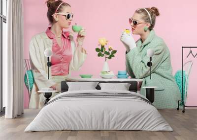 two girls blonde hair fifties fashion style drinking tea. Wall mural