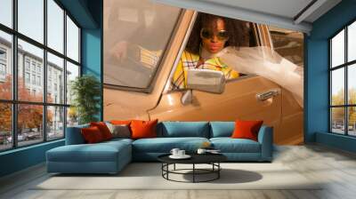 vintage 70s fashion afro woman with sunglasses driving in brown Wall mural