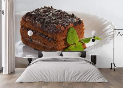 Chocolate cake with chocolate chips and mint on a white plate Wall mural