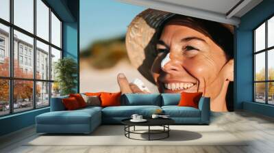 woman applying sunscreen cream on her face with hat Wall mural