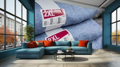  A stack of blue and gray clothing with the size label 2XL. Selective focus Wall mural