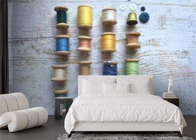 A set of different threads on wooden coils of different colors with colorful buttons and an old thimble of yellow metal Wall mural