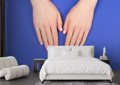 Manicure and nail care concept. Two woman hands with perfect pastel pink nail polish on blue background. Summer minimal manicure. Flat lay, top view. Copy space. Wall mural