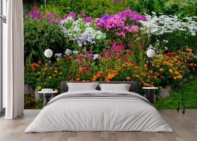 multicolored flowerbed on a lawn. horizontal shot. selective focus.Perennial garden flower bed in spring at flower show.Colorful flower bed with Gazania and Begonia,phloxes Wall mural