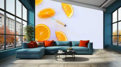 Reaching for vitamin C. ripe orange fruit with syringe extracting liquid and showing concept of cellulite treatment on white background.mineral cosmetic product and health nutrition. Copy space. Wall mural