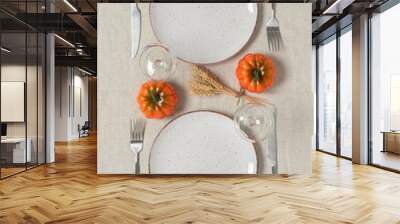 Thanksgiving autumn table setting for two. Empty plates, cutlery are decorated with pumpkins, dry leaves and ears of wheat. Top view, flat lay. Harvest concept. Wall mural